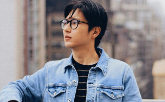 man wearing a denim jacket and black glasses